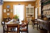 yellow kitchen/dining room with dark wood antique cabinet