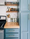 Blue kitchen with two small spice shelves