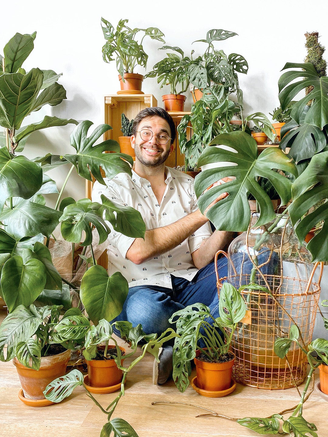 man sitting in room surrounded by plants