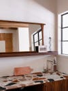 terrazzo counter in kitchenette below mirror