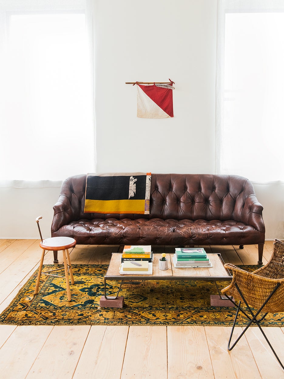 small yellow rug with leather couch