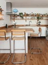 white kitchen with butcher block counters and blue pendant light