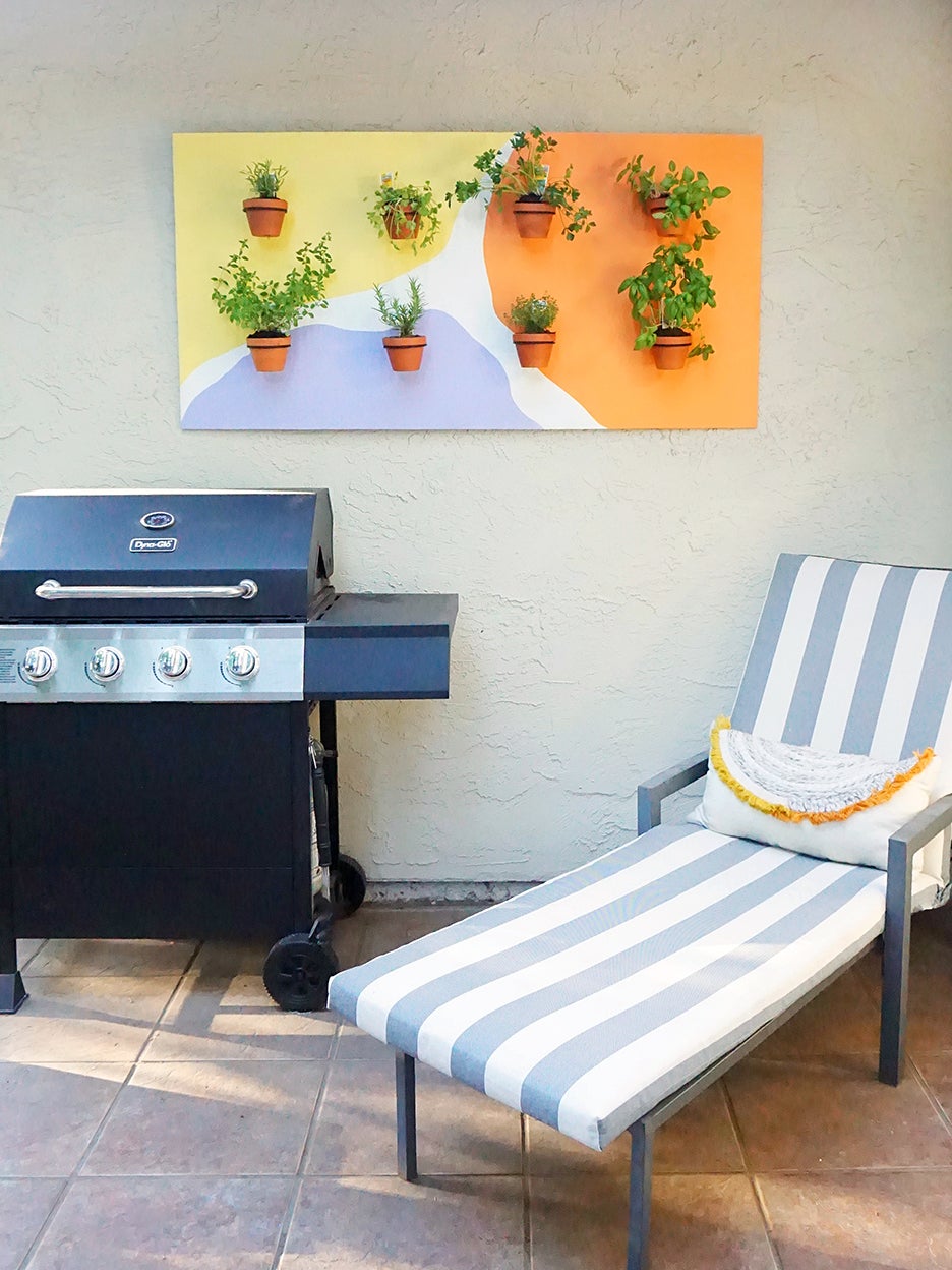 patio with hanging herb garden and blue striped lounger and grill
