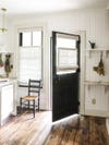 black door open in white kitchen