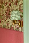 Floral fabric walls with brass sconce