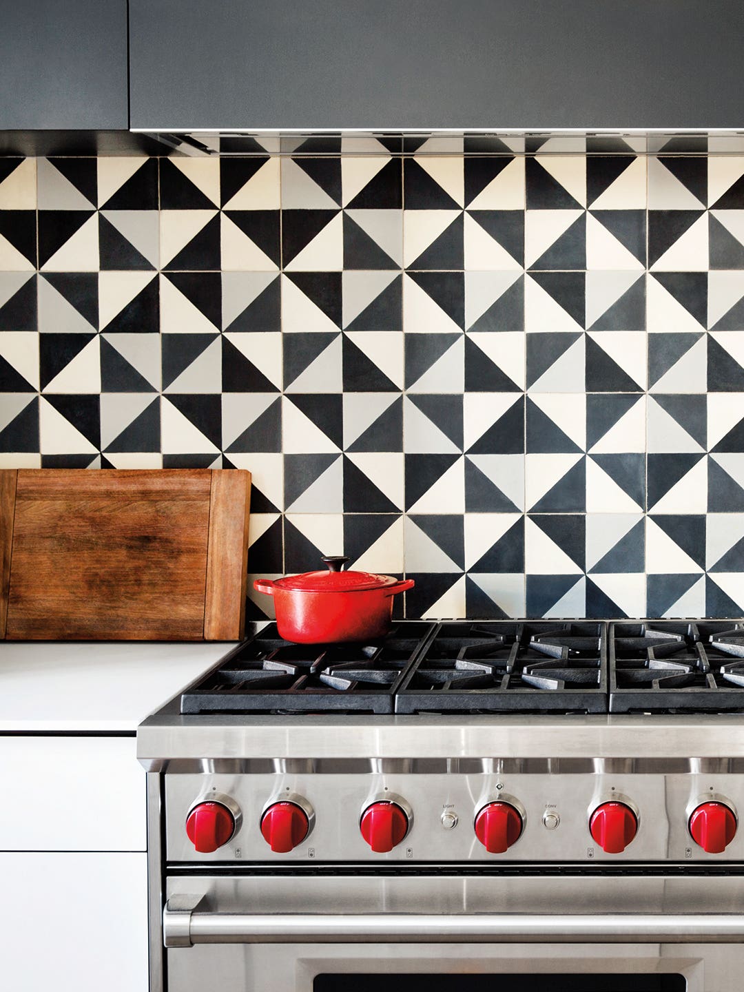 Black and white kitchen backsplash with red Dutch oven on stovetop