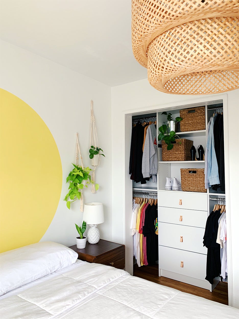 bedroom with yellow mural and open closet