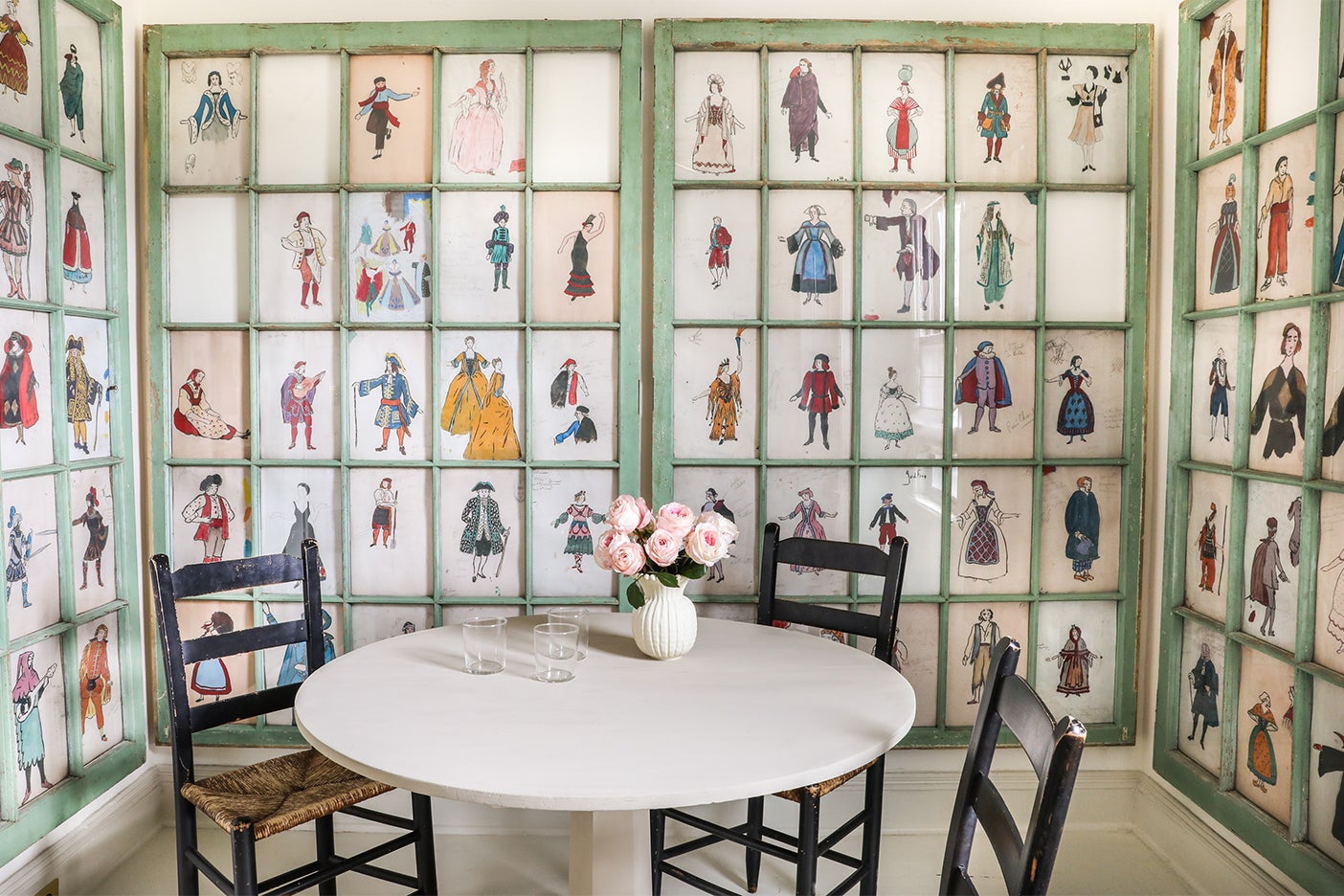 window panes filled with art pieces behind dining nook