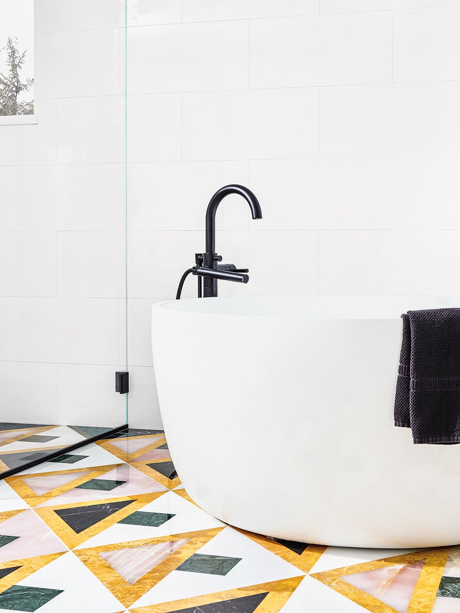white bathroom with tub and colorful marble tile floor