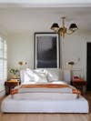 neutral bedroom with brass light pendant and Hermes blanket