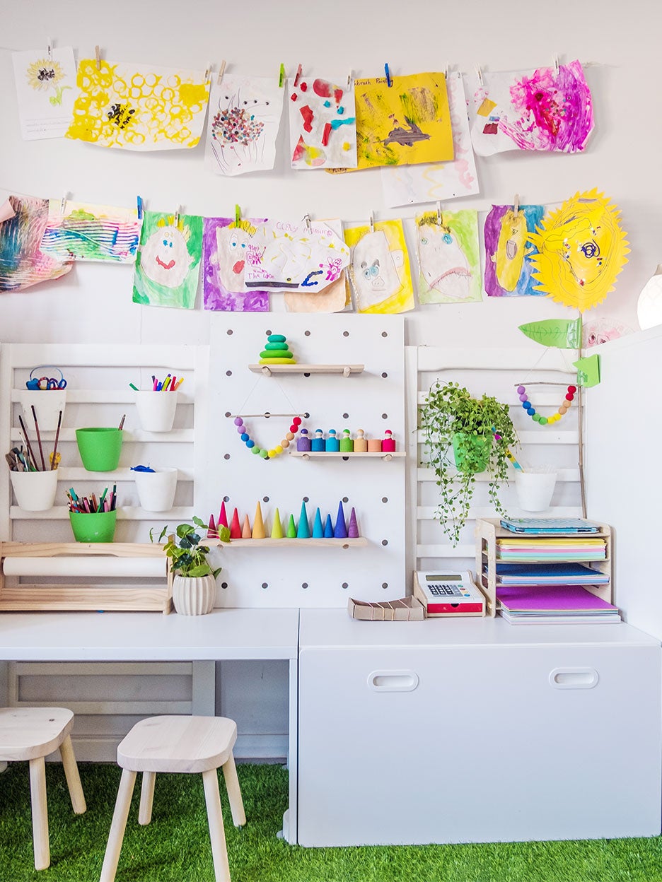 white kids art space with colorful paintings hanging