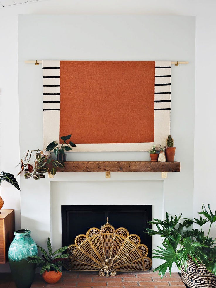 orange tapestry over fireplace