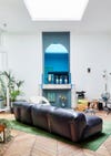 Black leather sofa placed diagonally above a green rug