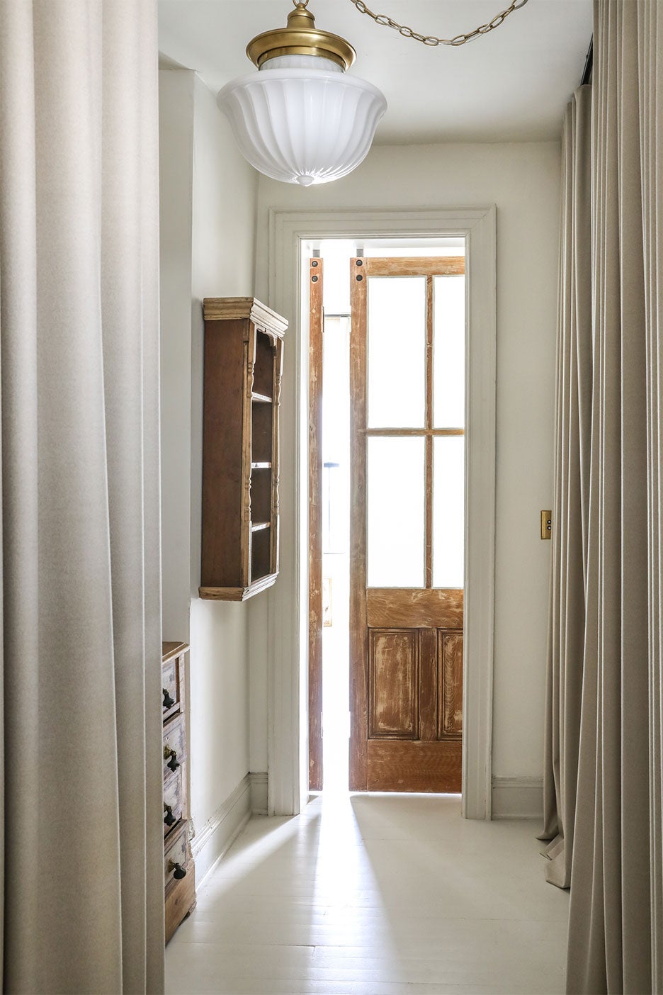 room with grey curtains and wood door