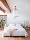 white bedroom with giant paper lantern hanging over bed