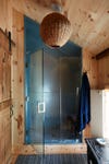 Wood-paneled bathroom with galvanized steel shower