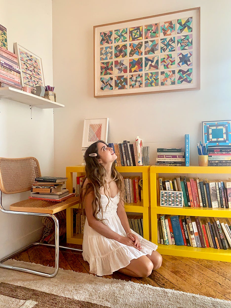 Molly Young in front of yellow bookshelf