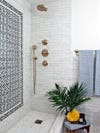 light gray tiled shower nook with black mosaic