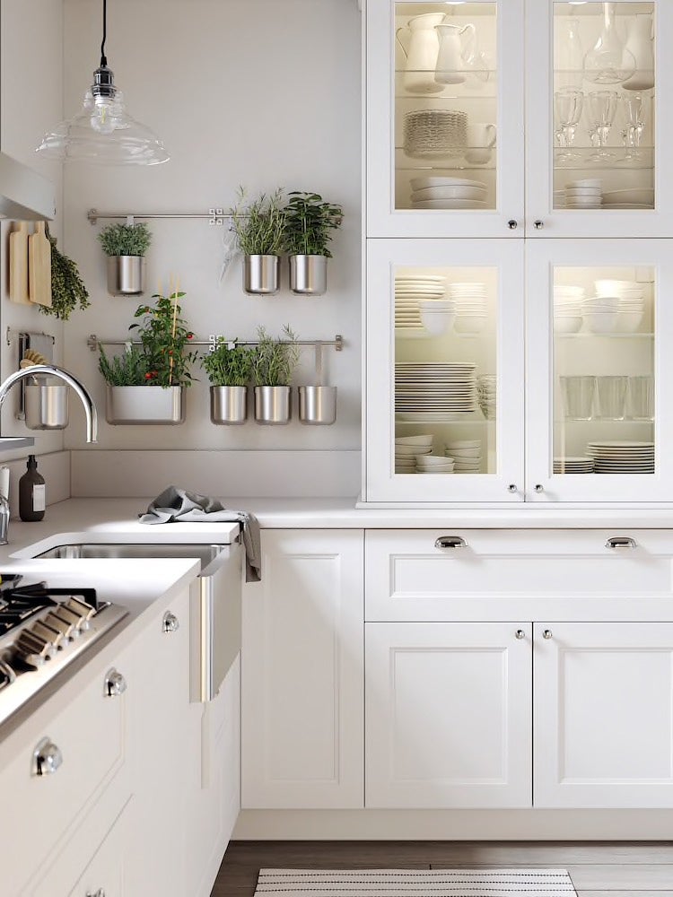 simple white kitchen with stainless steel herb pots