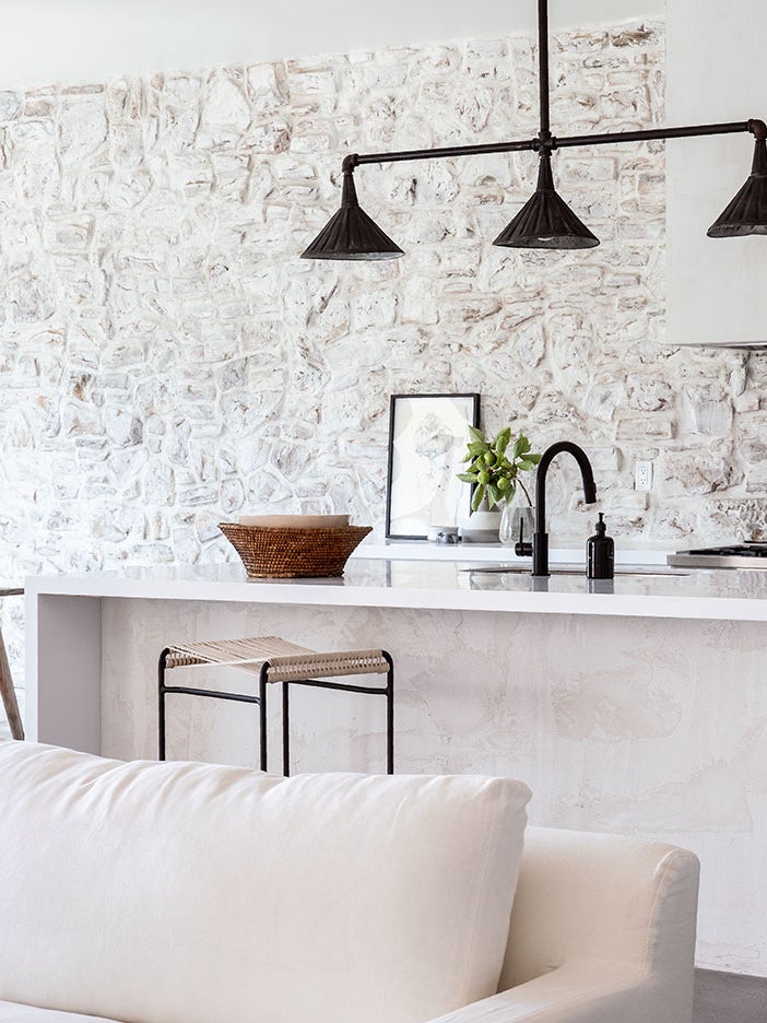 white kitchen with stone walls