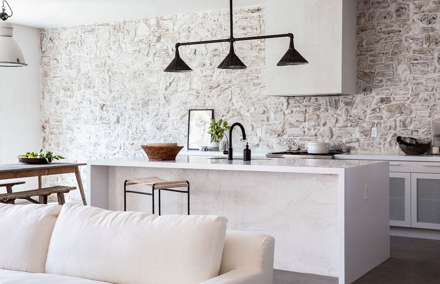 white kitchen with stone walls