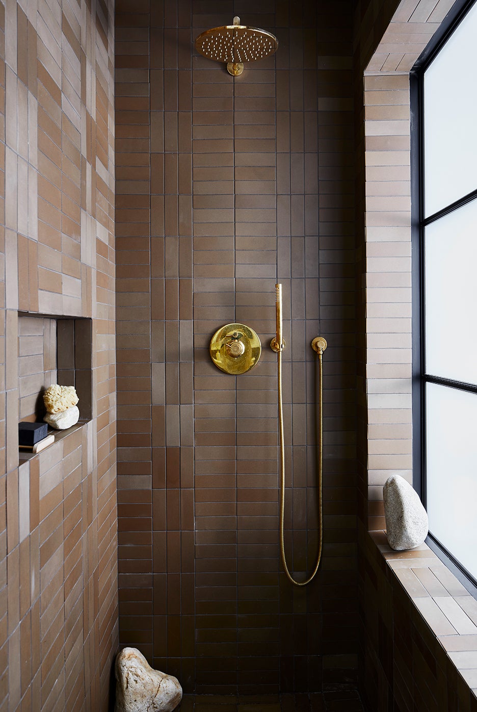 Brown shower tile with brass fixtures