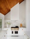 white kitchen with sloped wood ceiling