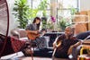 Stephen Burks and Milka Leiper playing guitar in living room