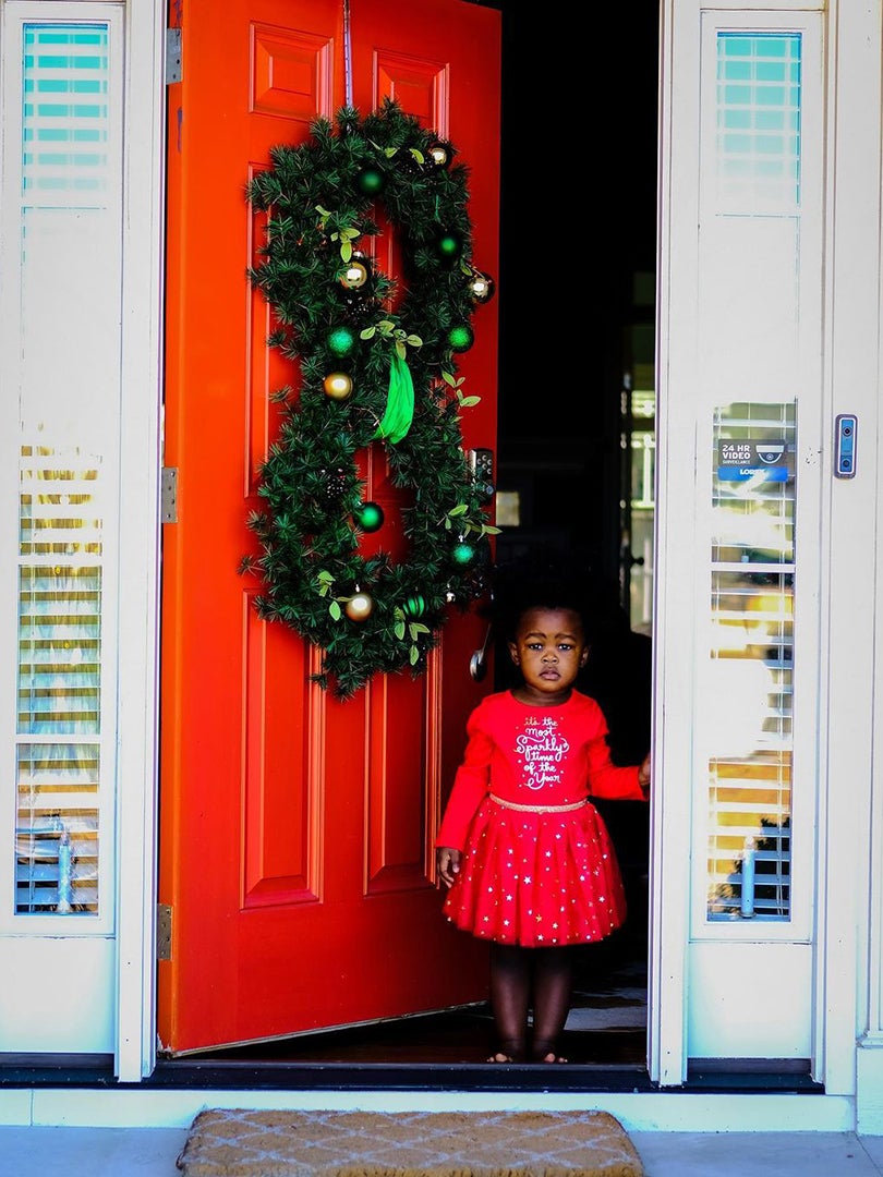girl standing in front of red door