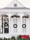 white house with green wreaths
