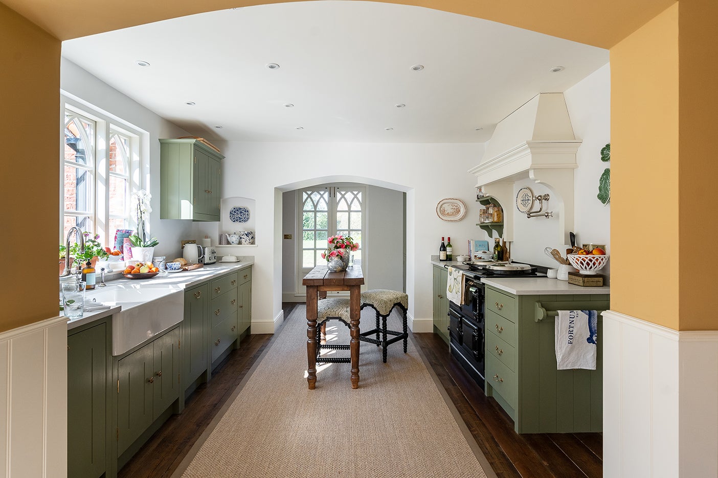 Green and white kitchen with arched doorway