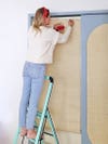 woman hanging fabric on door