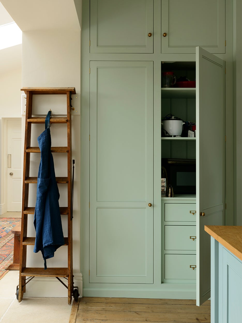 green pantry cabinet next to a ladder
