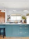 Blue-green kitchen with oak pantry door