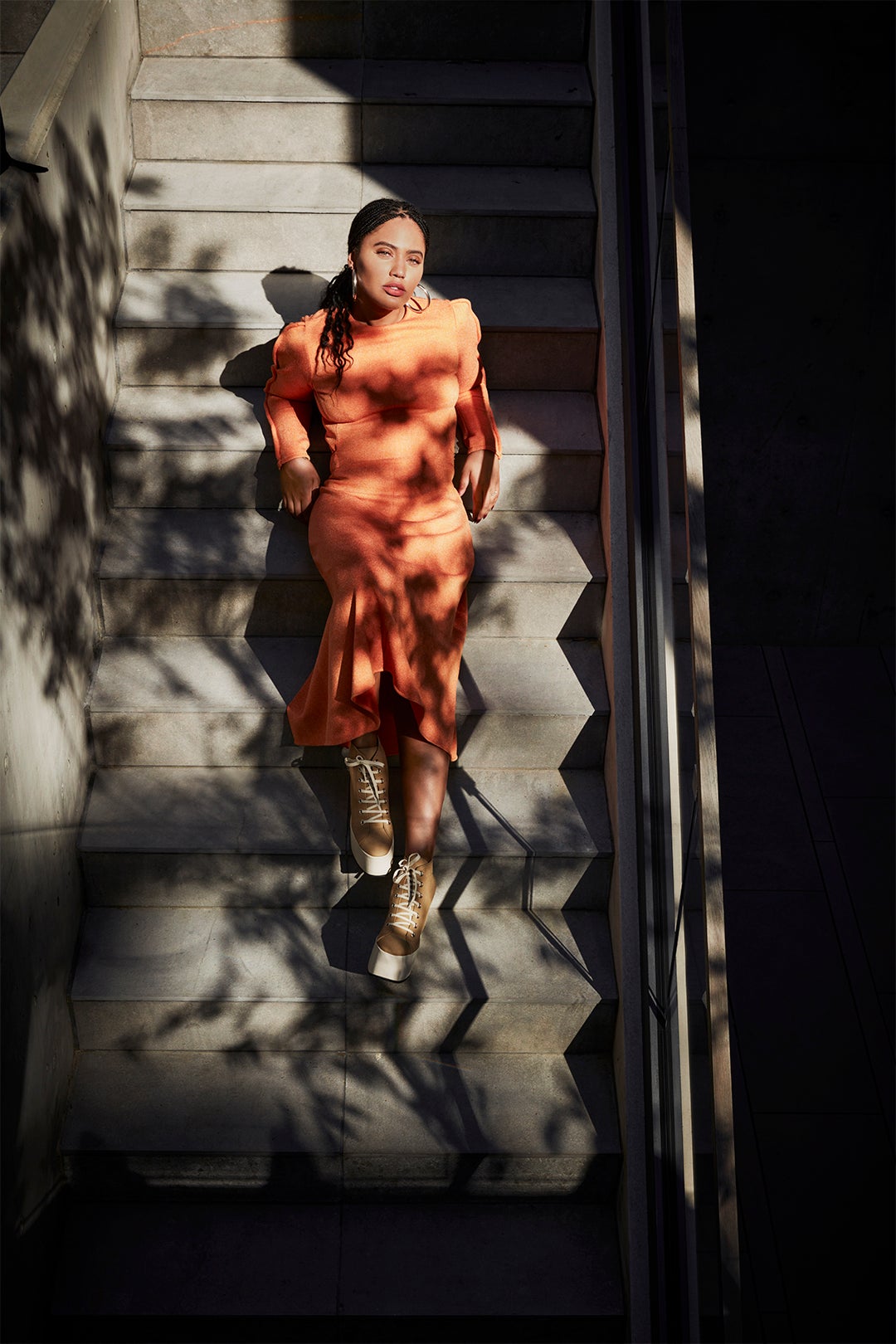 Ayesha Curry on steps in orange dress