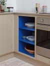 Small kitchen with cobalt blue painted shelves. 
