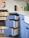 Small kitchen with blue corner drawers. 