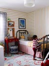 Boy climbing up on his bed with striped beige walls behind him.