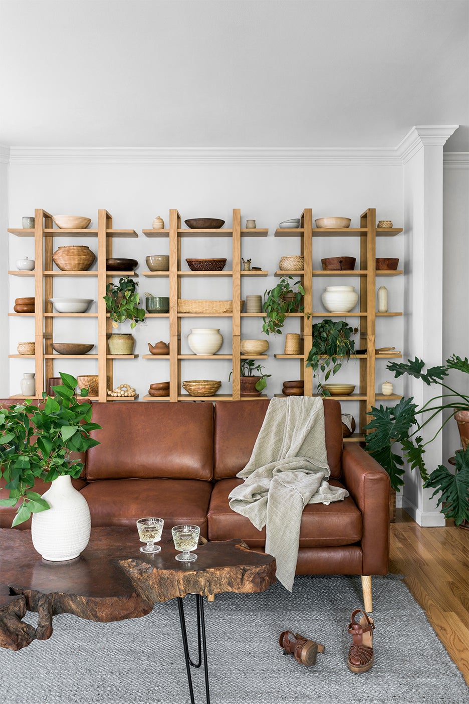 Pottery filled shelves and leather sofa