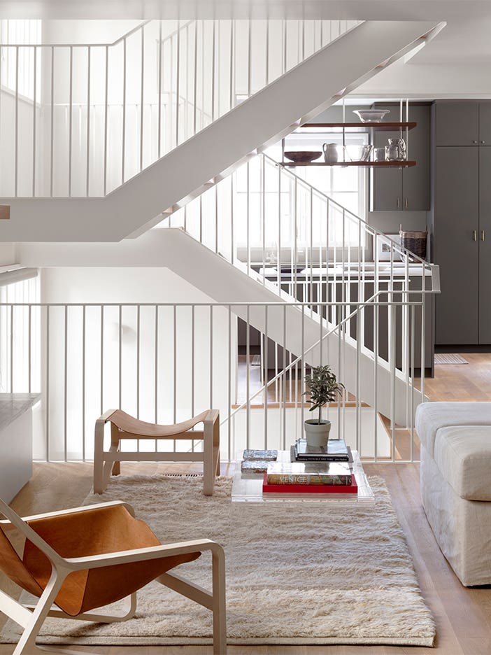 White modern staircase with gray kitchen