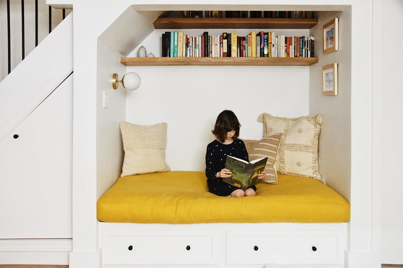 girl reading book on couch