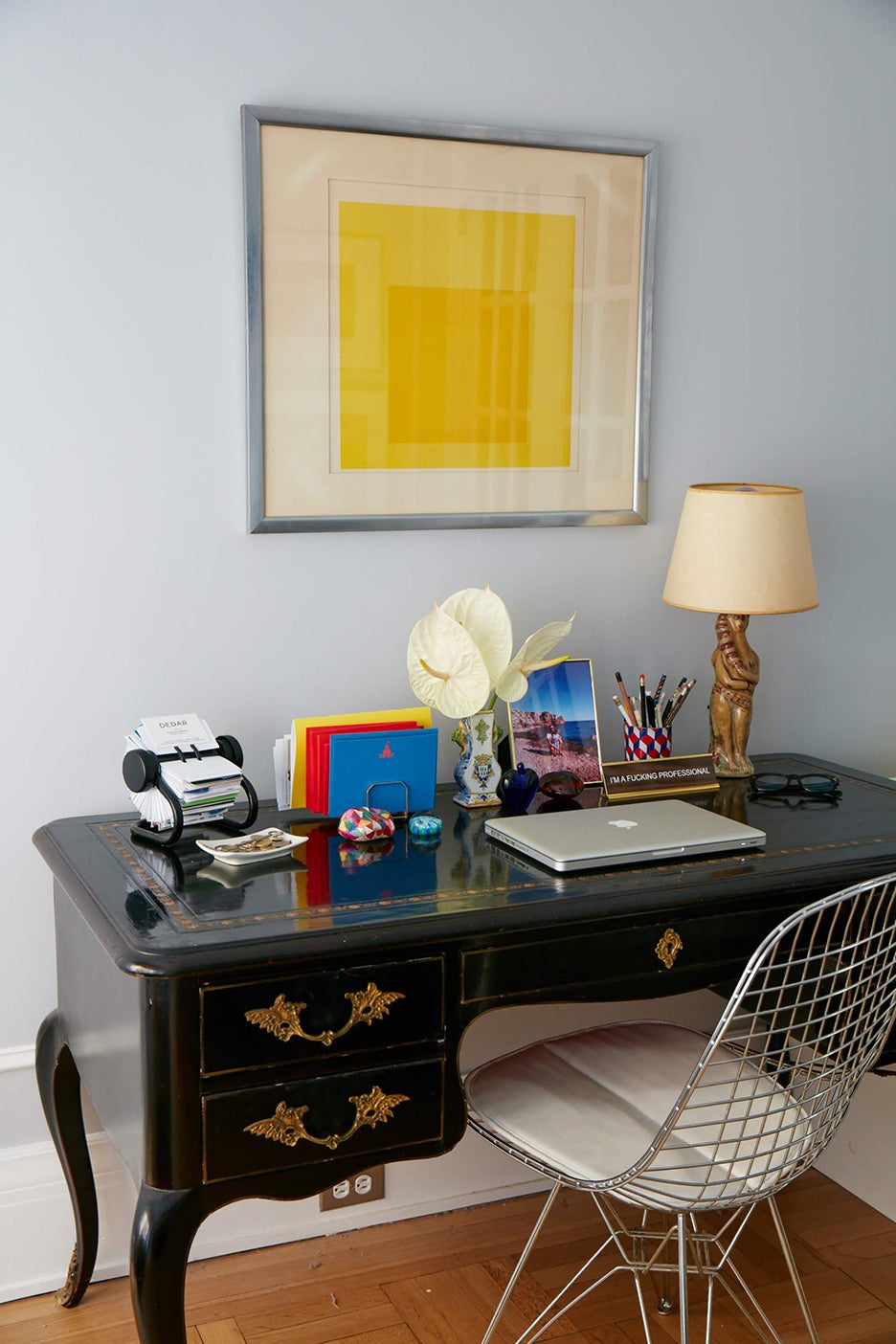 a yellow painting above a desk