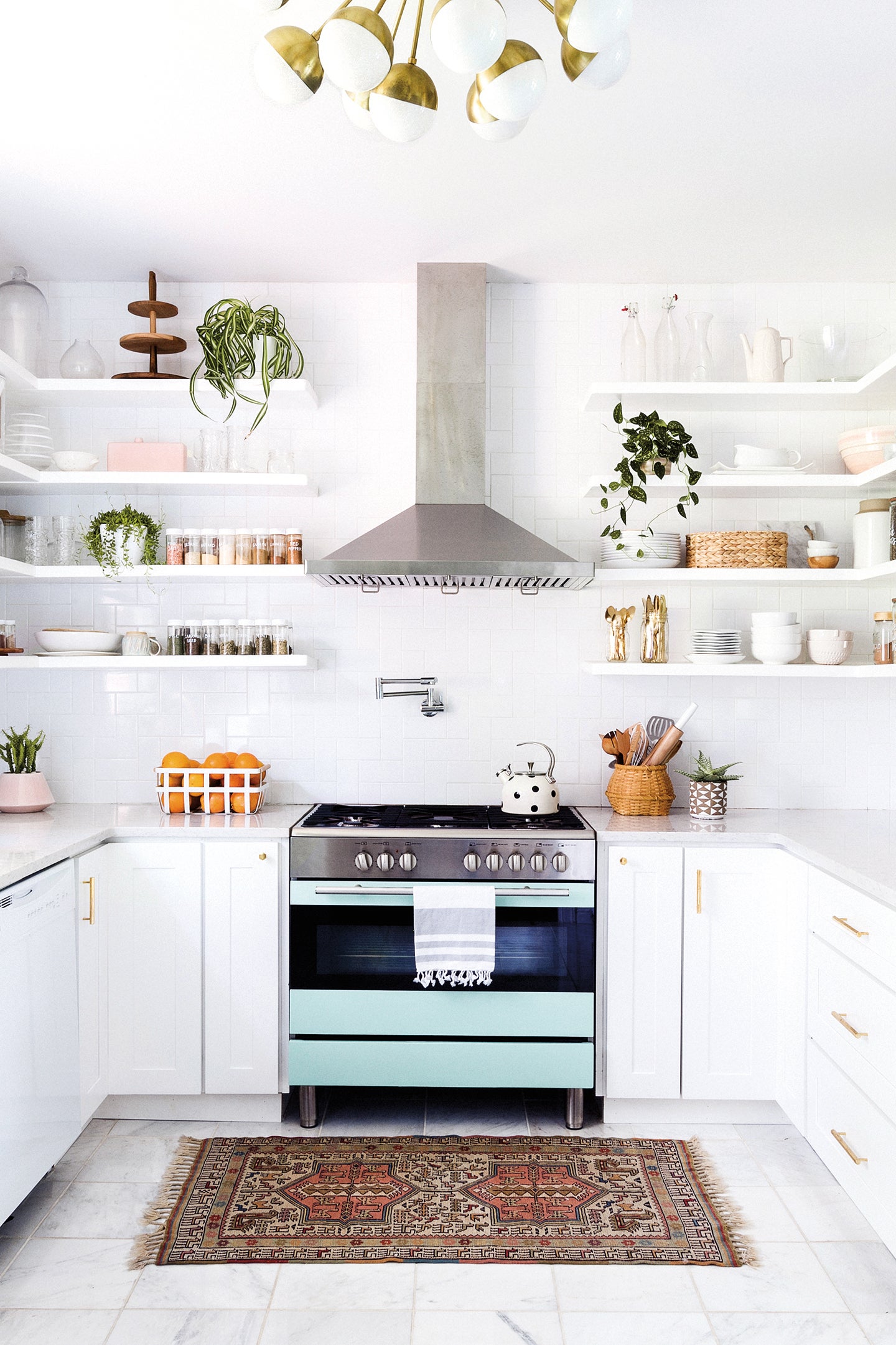 White kitchen with blue oven and open shelving