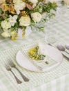 Light green gingham tablecloth layered with matching placemat and napkin