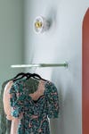 clothes hanging on mint green painted pipe