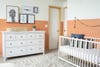 Terracotta rooms - white crib with peach mural on wall 