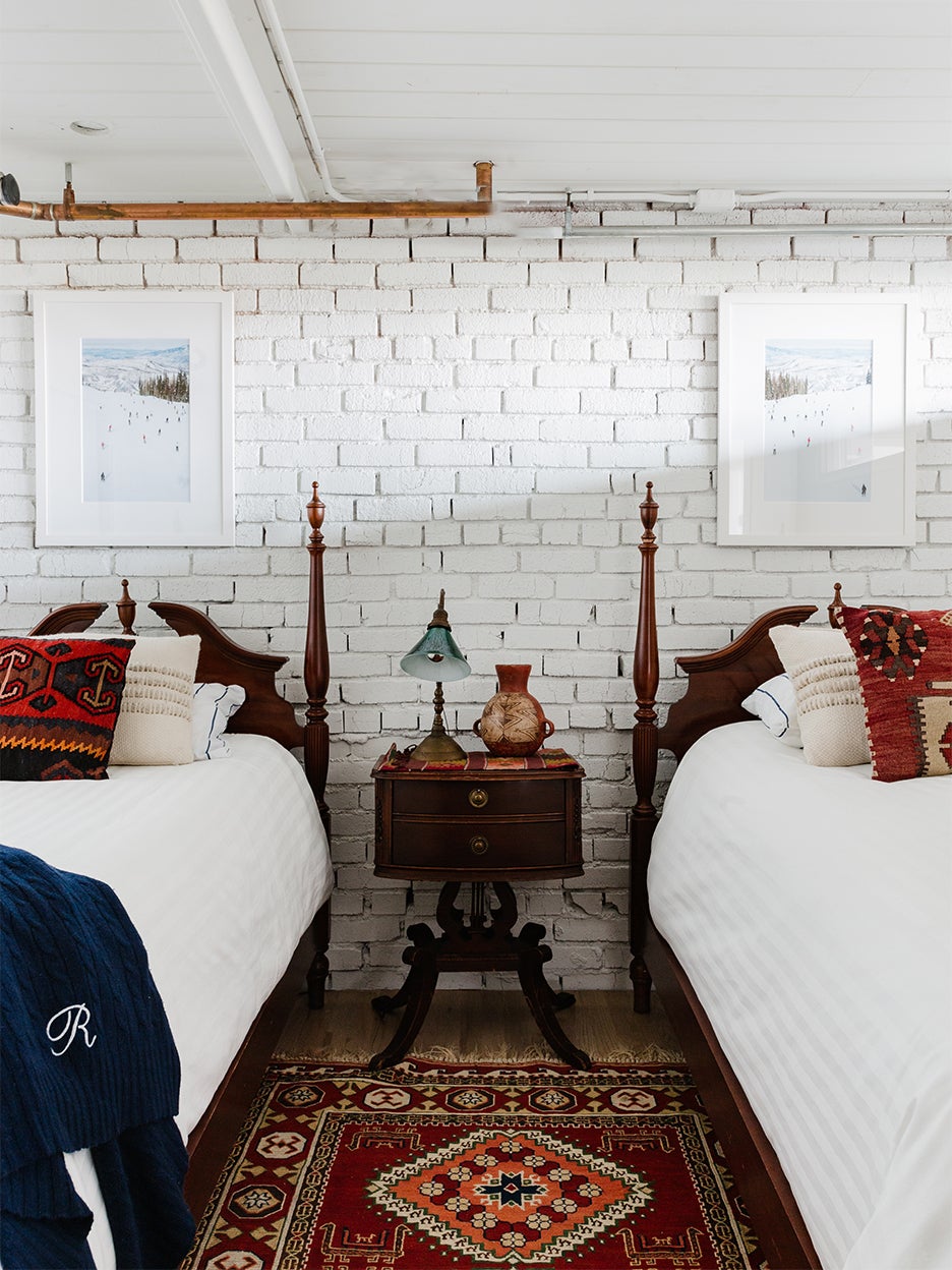 twin beds in front of painted brick wall