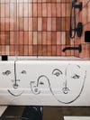 abstract faces on side of white tub