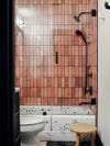 pink tiled shower with artful tub