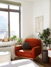 orange velvet chair in corner of bedroom